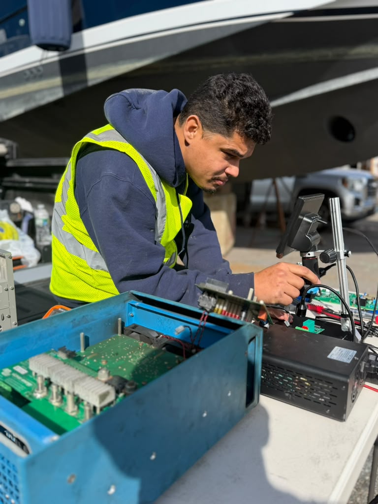 Technician diagnosing an inverter power board at the boatyard